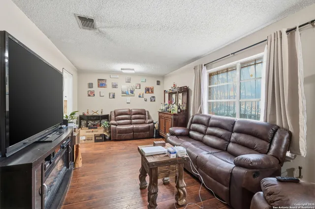 a living room with furniture a flat screen tv and a large window