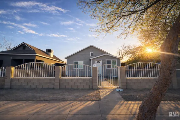 a view of a house with a small yard and wooden fence