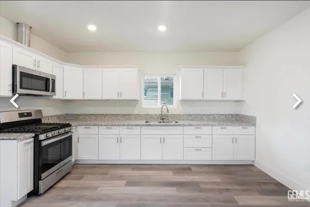 a kitchen with granite countertop cabinets stainless steel appliances and a sink