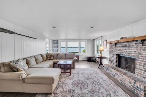 a view of a livingroom with furniture wooden floor and a large window