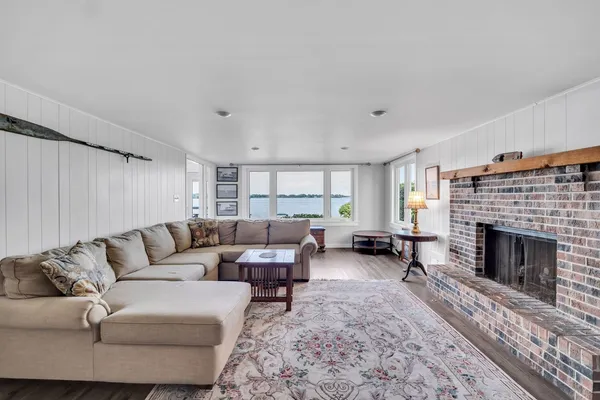 a view of a livingroom with furniture wooden floor and a large window