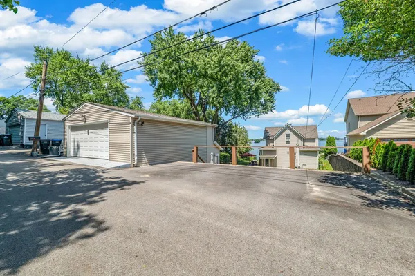 a view of a house with a small yard and a large tree