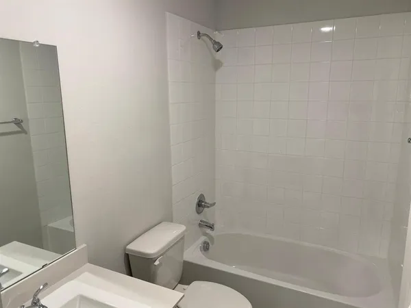 a white toilet and tub next to a bathroom sink