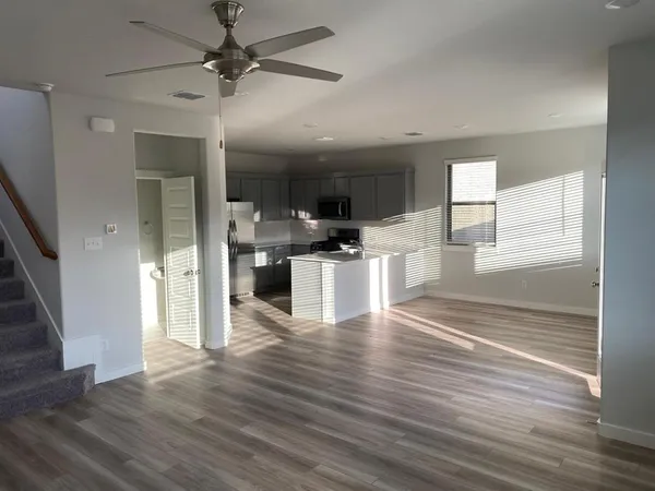 an open kitchen with stainless steel appliances granite countertop a refrigerator and microwave