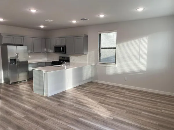 a kitchen with kitchen island a sink stainless steel appliances and cabinets