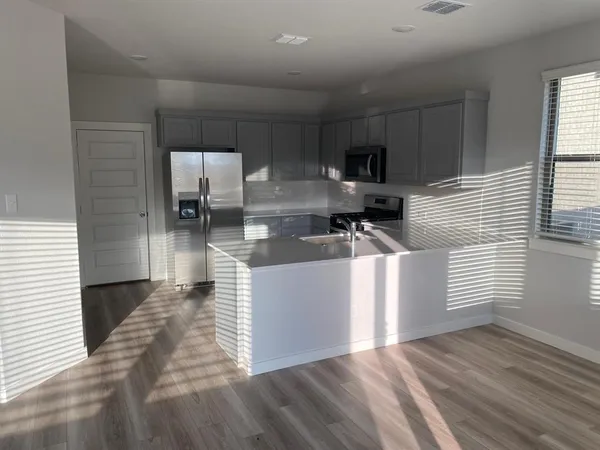 a kitchen with stainless steel appliances a refrigerator sink and microwave