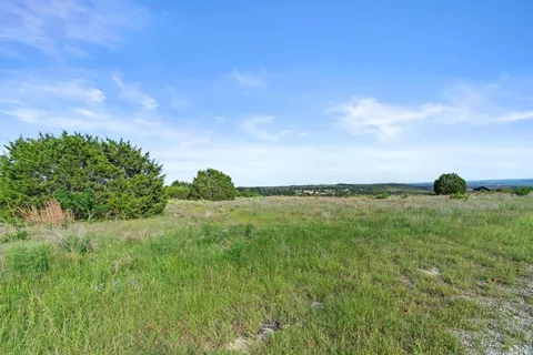 a view of a lake and green valley