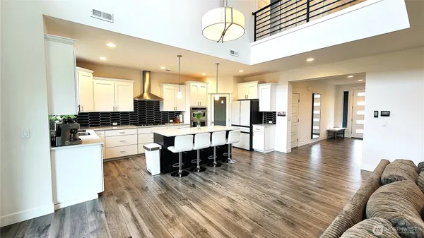a large white kitchen with lots of counter space and furniture