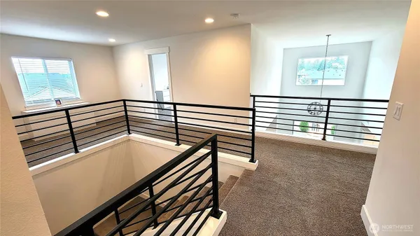a view of a hallway with stairs and a window