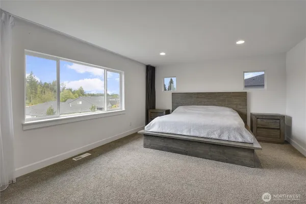 a large bed sitting in a room next to a window