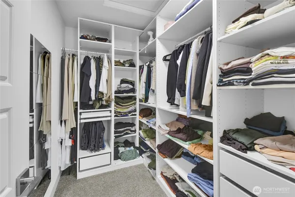 a view of walk in closet with clothes and shoes