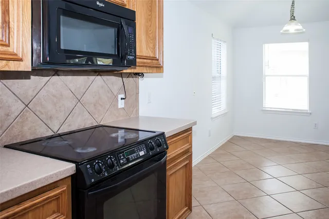 a view of an empty room with wooden floor and a ceiling fan