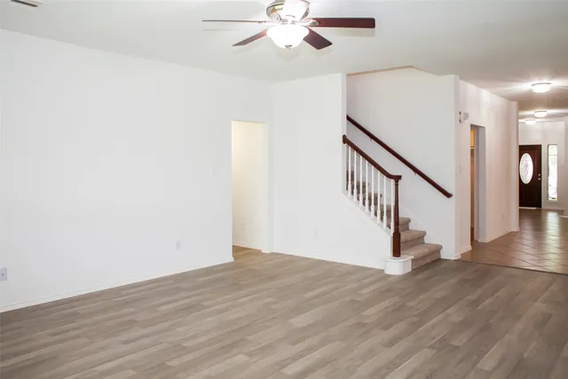an empty room with a window and a fan