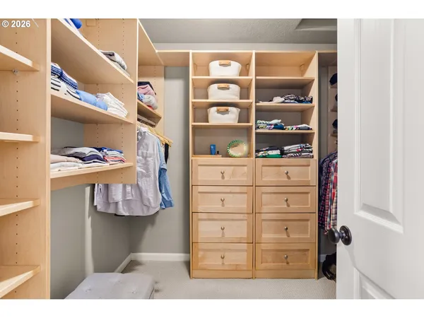 a view of walk in closet with clothes