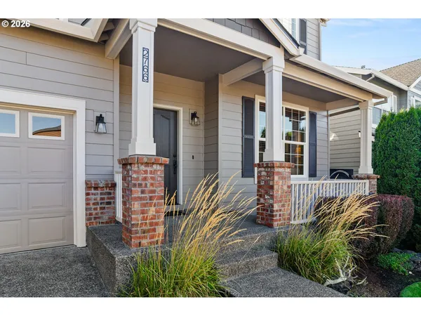 a view of a patio with table and chairs potted plants and floor to ceiling window