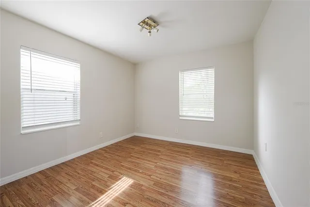 a view of a room with wooden floor and windows