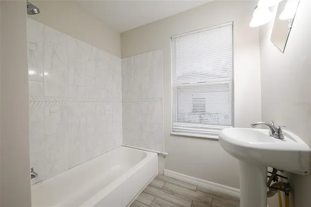 a bathroom with a sink a bathtub and a window