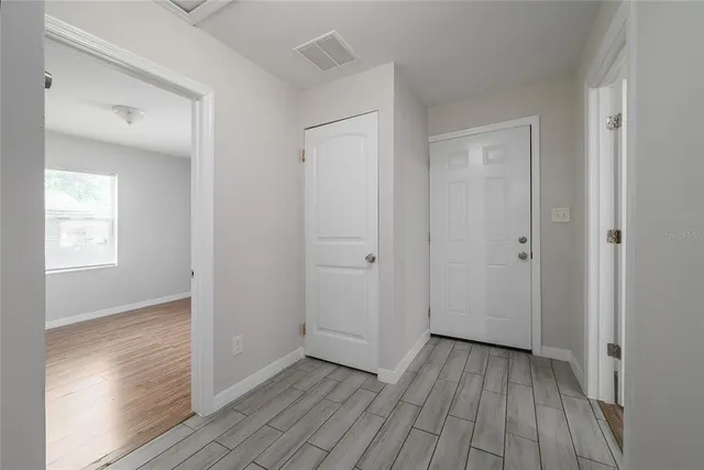 a view of a hallway with wooden floor