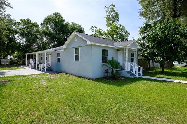 a view of a house with a yard and sitting area