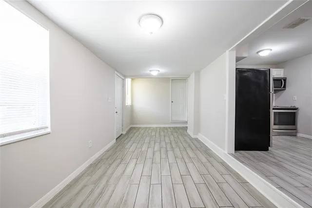 a view of empty room with wooden floor