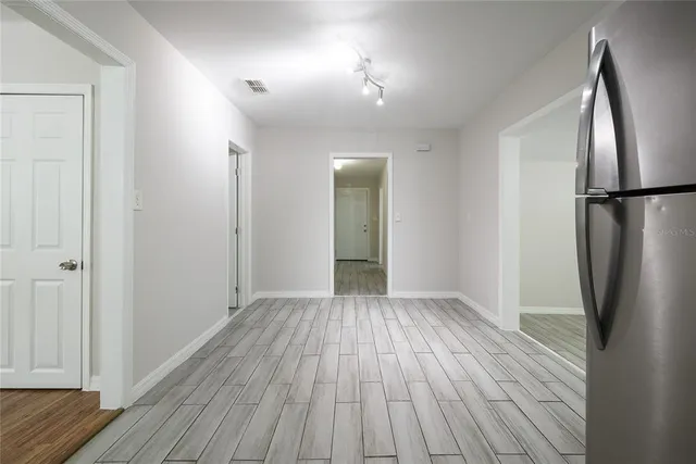 an empty room with wooden floor and a bathroom