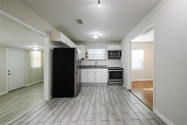 a kitchen with a refrigerator and a stove top oven