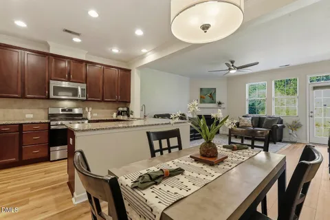 a kitchen with a table chairs stove and kitchen view
