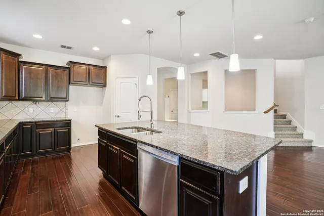 a kitchen with stainless steel appliances granite countertop a sink a stove and kitchen island