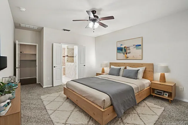 a spacious bedroom with a bed and a chandelier