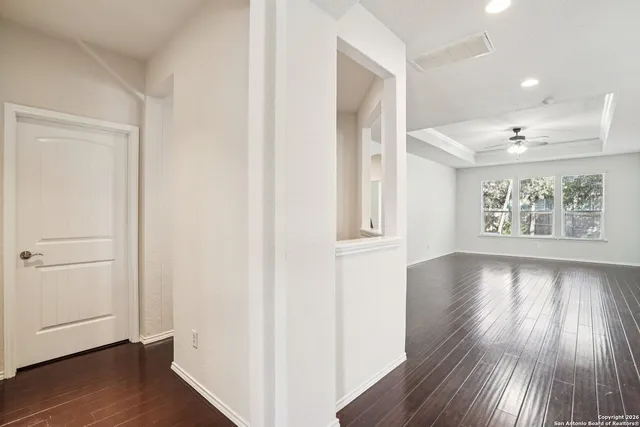 an empty room with wooden floor and windows
