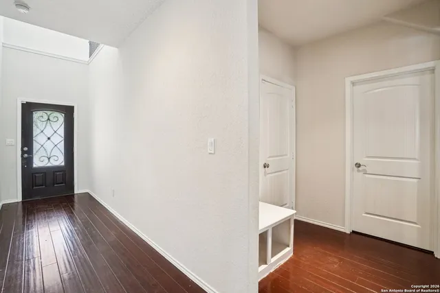 a view of an empty room with wooden floor