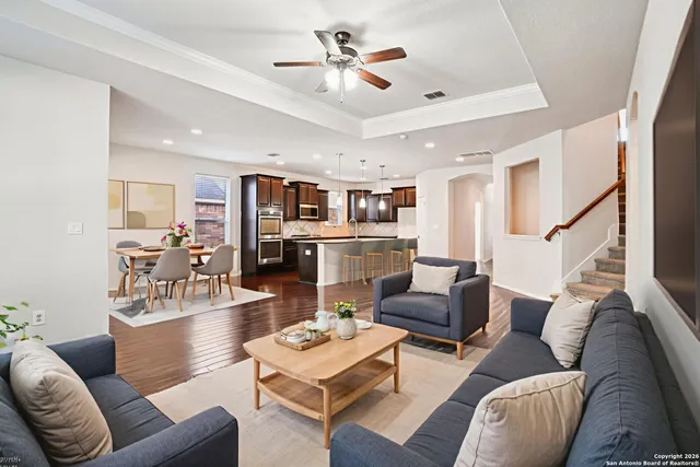 a living room with furniture kitchen view and a chandelier