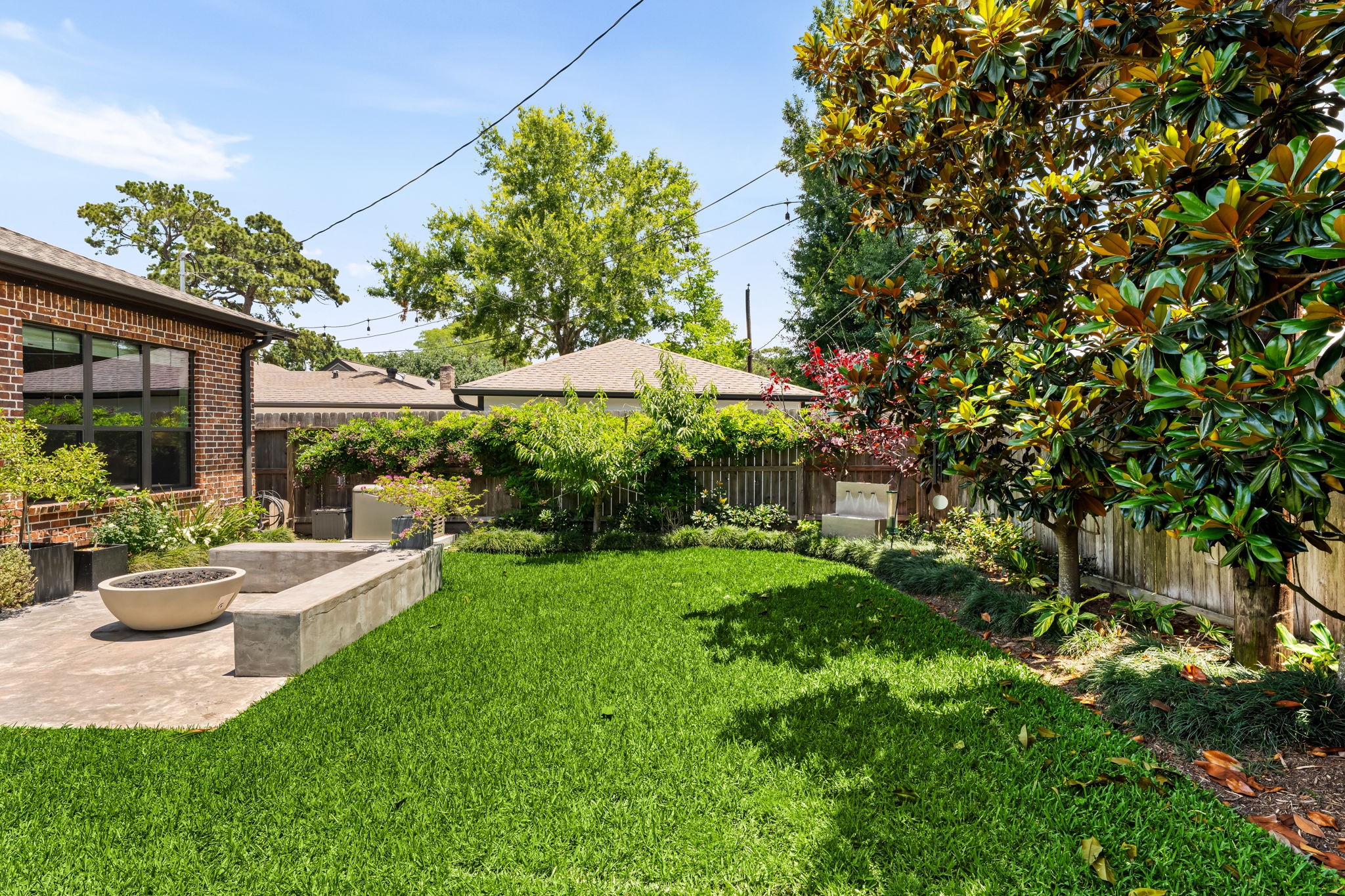 1013 Martin Street Houston, TX 77018 - Photo 39 of 46 Beautiful outdoor space offering mature landscaping, spring lights, water feature, expansive green space, & room for kids & pets to play. Sprinkler system and gutters installed.