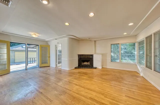 a view of an empty room with a fireplace and a window