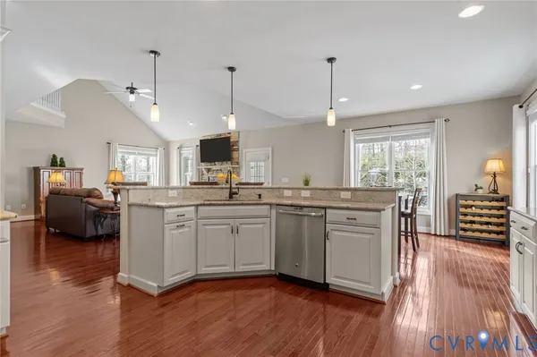 a kitchen with granite countertop wooden floor stainless steel appliances and sink