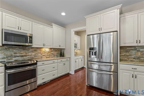 a kitchen with granite countertop stainless steel appliances and wooden floor
