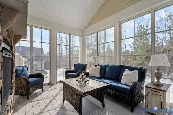 a living room with furniture a fireplace and a floor to ceiling window