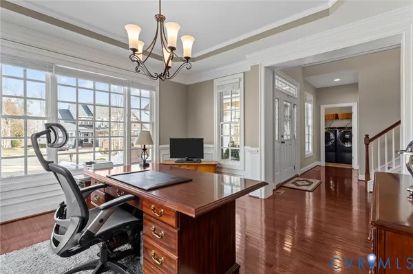 a kitchen with granite countertop white cabinets and wooden floor