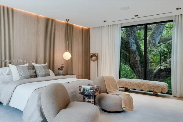 a bedroom with furniture and a large window