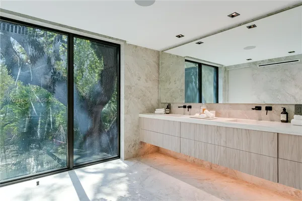 a bathroom with a double vanity sink mirror and shower