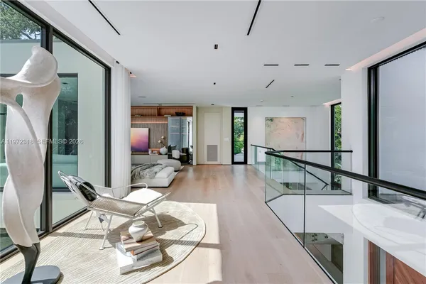 a living room with furniture a wooden floor and large windows