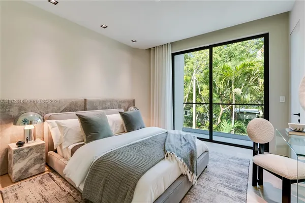 a bedroom with a bed and a large window