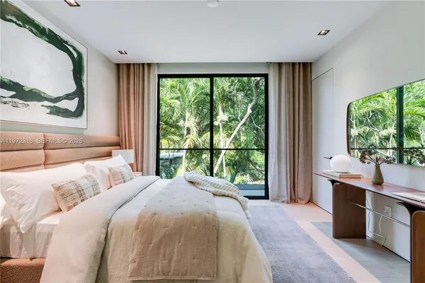 a bedroom with a large bed and a large window