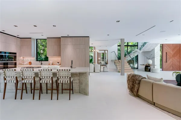 a large white kitchen with lots of counter space and windows