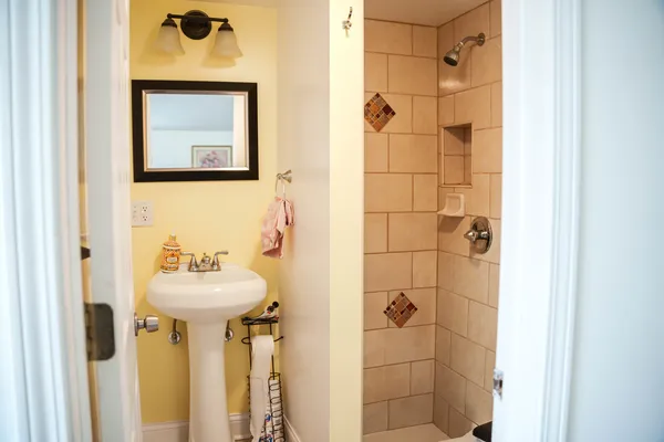 a bathroom with a sink mirror and shower