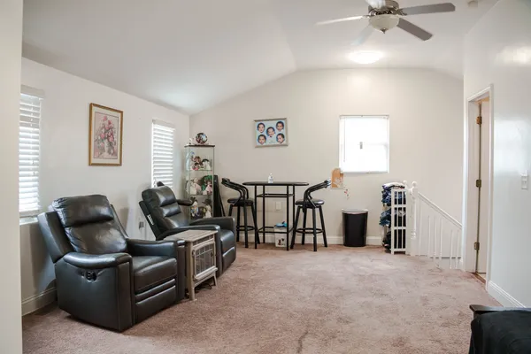 a living room with furniture and a ceiling fan