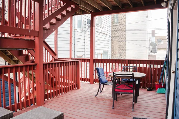 a balcony with wooden floor and outdoor seating