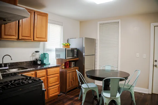 a kitchen with stainless steel appliances a stove a sink dishwasher and white cabinets with wooden floor