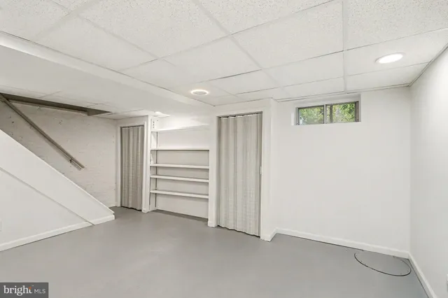 a bathroom with a sink a chair and a window