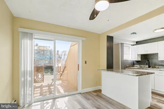 a kitchen with a refrigerator a stove top oven a sink and wooden floor